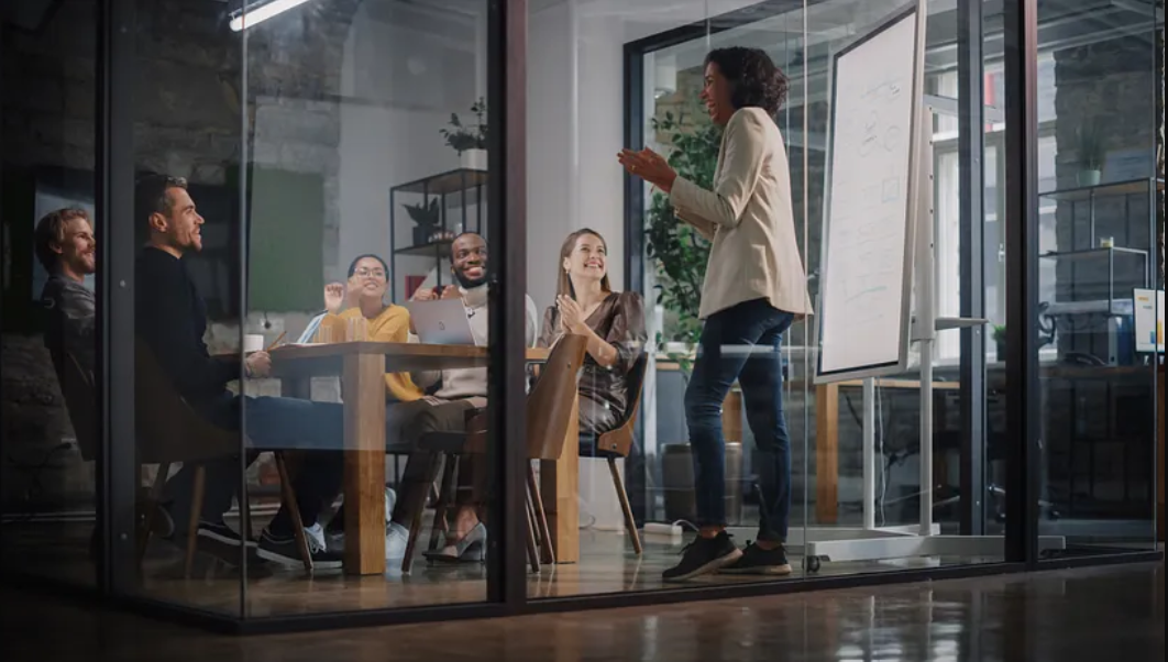 Speaker in a meeting in a glass-walled office.